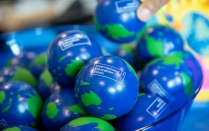 A hand picking up one small globe from a bowl of globes. 