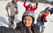 Picture of four students posing for a picture in the snow wearing downhil skiing equipment. 