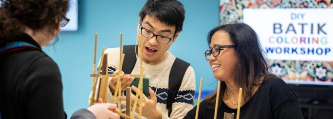 Students try out the angklung, an Indonesian musical instrument, as part of International Education Week. 