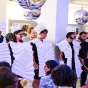 People wearing sculpted paper costumes. 