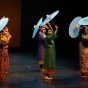 performers on stage with decorative umbrellas. 