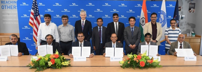 UB administrators and others posing with signed papers. 