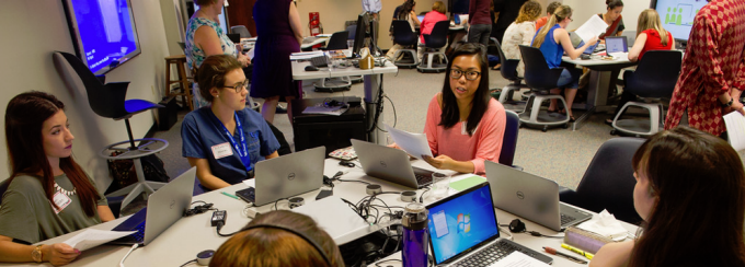 Student team gathered around a table in mid-discussion.