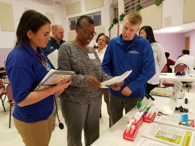 Team members standing in front of a table reviewing instructions.