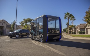 Ollie (an autonomous bus) driving down a street. 