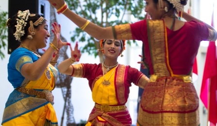 Three Indian dancers in colorful dresses. 