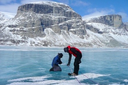 Two researchers working on large ice sheet. 