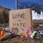 carboard sign that reads 'love over hate' at a memorial. 