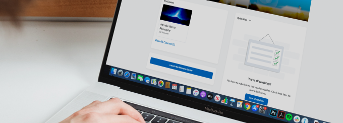 An individual typing on a computer, the Brightspace homepage is displayed on their screen. 