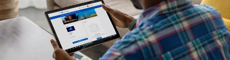 A man holding a tablet with the Brightspace dashboard displayed. 