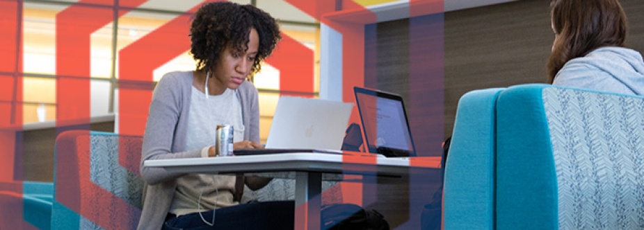 Person sitting at booth looking at a laptop. 