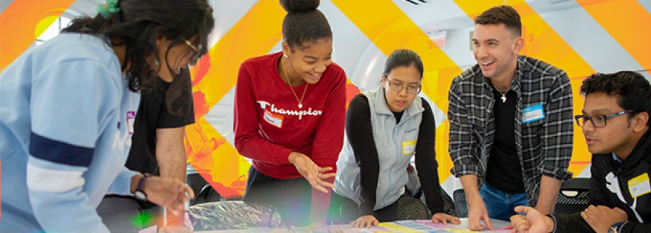 Group of students talking to each other and leaning on a table. 