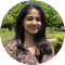 Portrait photo of Sravya Koduro, with trees in the background, circular cropping.
