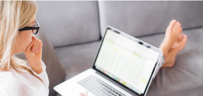 woman sitting on couch with laptop. 