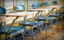 empty desks lining the back of a classroom. 