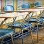 empty desks lining the back of a classroom. 