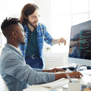 Two men at a computer screen. 