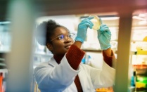 graduate student inspects a sample in a laboratory. 