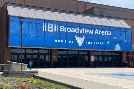 Exterior entrance of UB&rsquo;s Broadview Arena, featuring blue &ldquo;Home of the Bulls&rdquo; signage, brick walls, and a landscaped plaza. 
