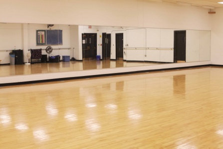 Dance studio in Broadview Arena with a polished wood floor, wall-length mirrors, ballet barres and open space for movement and practice. 
