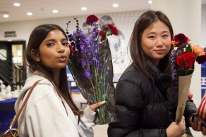 Two students pose with colorful bouquets they created during a Halloween event at Broadview Arena.