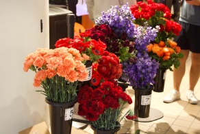 Colorful carnations, roses and other flowers are arranged in numbered containers for participants to create bouquets.