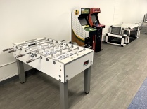 UB Recreation Lounge game area featuring a foosball table, Golden Tee and NBA Jam arcade games, and Subsoccer tables.