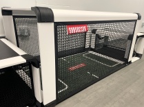 Subsoccer table featuring a miniature soccer field, goals, surrounding netting and seats for two players.