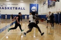 UB students play basketball in the Ed Wright Practice Facility as one player drives toward the basket.