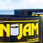 close up image of woman holding a yellow frisbee with "KAN JAM" overlaying it in yellow with black outline. 
