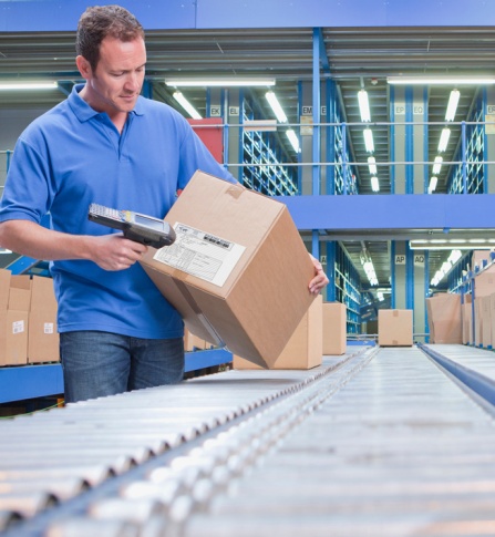 Employee scanning a package on a conveyor belt. 