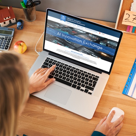 Woman using a laptop browsing the AI Innovation Exchange. 