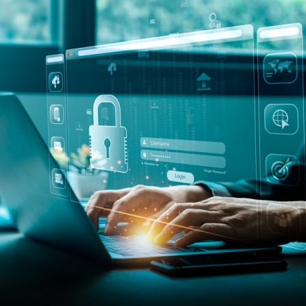 Researcher using secure laptop to save data; virtual icon of lock and security network in foreground. 