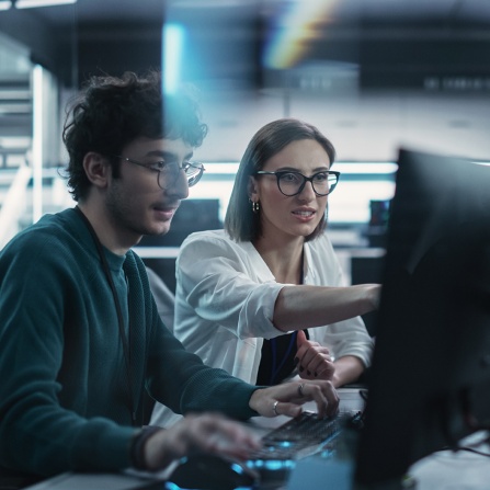 Male and female working on computer. 