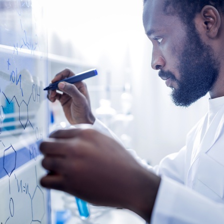 researcher writing formula on board. 