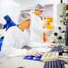 Students in white sanitary suits using a cleanroom on UB campus. 