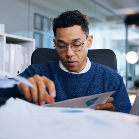 Associate reviewing compliance documents as his desk. 