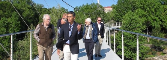 A group of people walking along a bridge for a site visit of an RBA finalist site.