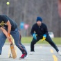 Students playing cricket on campus. 