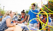 Two people talking during campus fest at a tabling event.
