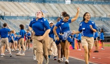 Orientation leaders run onto the field at UB Stadium during new student welcome event.
