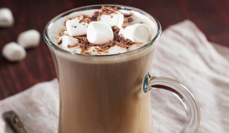 A glass mug of hot chocolate with mini marshmallows on top.