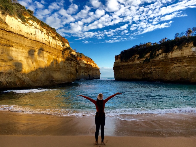 Student with Arms in the Air in front of Australian Coast/Seascape. 