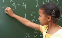 Girl writing on chalkboard. 