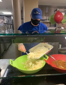 student volunteer serves rice. 