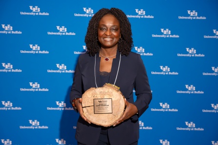 Dorothy Siaw-Asamoah holding the 2026 SLICE award in front of a UB logo background. 
