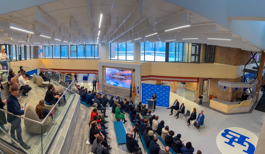 Interior of The Landing at Ellicott with a tiered seating areas and a big screen that says "Landing". 