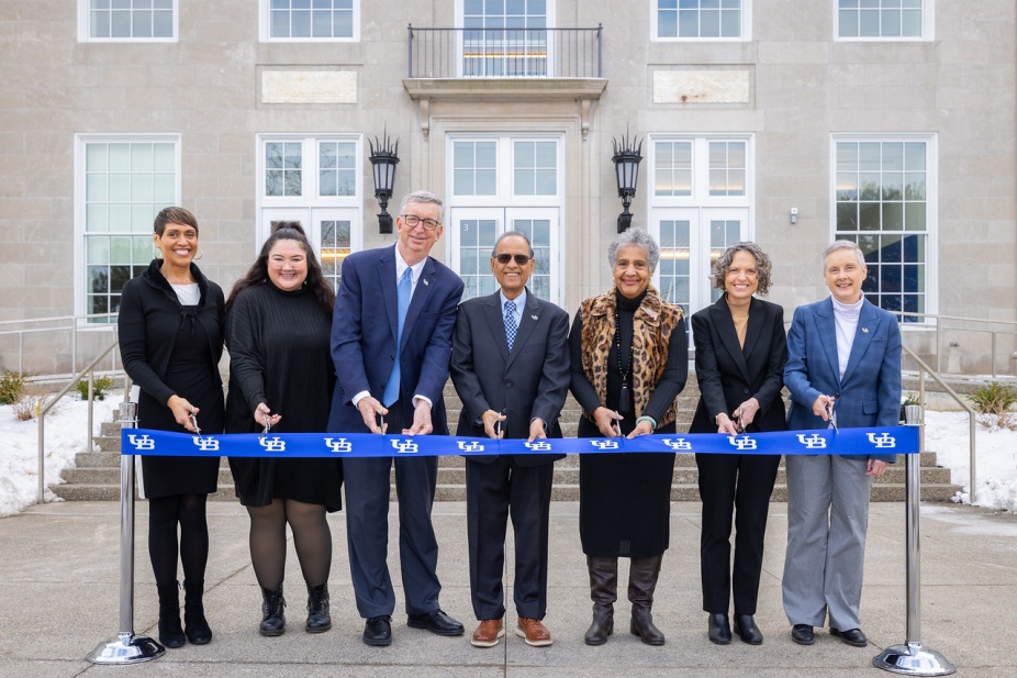 A group of people prepare to cut the ribbon for the opening of Foster Hall. 