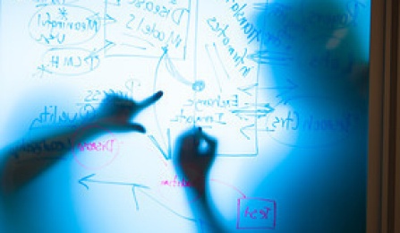 Two people strategize on a white board in the UB New York State Center of Excellence in Bioinformatics and Life Sciences. 