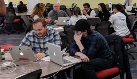 Various teams ponder their solutions at the area's first UB Blockchain Buildathon. 